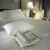 A Book with Glasses Left on the Bed Photographic Print