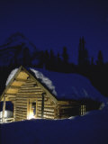 Woman in Doorway of Snow-covered Cabin at Night Photographic Print