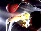 Rear View of a Boxer Punching a Punching Bag Photographic Print