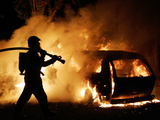 A Firefighter Extinguishes a Car in Les Musicians Photographic Print