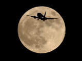 An Airliner is Silhouetted against a Full Moon Photographie