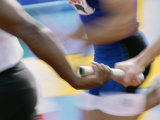 Mid Section View of Runners Exchanging Baton at a Relay Race Lámina fotográfica