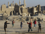 Afghan Boys Play Soccer Near a Mosque and Ruined Buildings During the Early Morning Fotografie-Druck