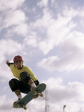 Low Angle View of a Young Man Skateboarding in Mid Air Lámina fotográfica Low Angle View of a Young Man Skateboarding in Mid Air Lámina fotográfica