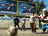 Iraqi Boys Play Soccer Below the Poster Reading "To Grant Iraqi Children Better Iraq" Photographie