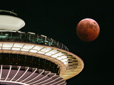The Full Moon Turns Red and Orange as It Passes the Space Needle Photographic Print