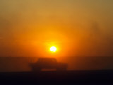 An American Humvee Drives Through the Desert at Sunset Near the Iraqi Border Photographic Print