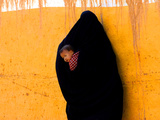 A Veiled Woman Carries Her Child Through the Streets of Erfoud Photographic Print