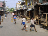 Children Play Soccer on One of the Streets of the Business District of Lagos Fotografisk tryk Children Play Soccer on One of the Streets of the Business District of Lagos Fotografisk tryk