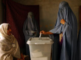 An Afghan Woman Wearing a Burqa Casts Her Ballot at a Polling Station Photographie