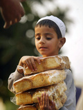 A Boy Carries Rusk as He Assists Others to Send a Consignment of Relief Supplies to Uri Photographic Print