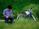 Man Using Laptop Computer Beside His Bicycle Near Kamogawa River, Kyoto, Japan Photographie par Frank Carter
