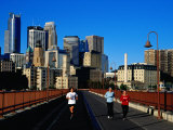 Women Jogging Across Stone Arch Bridge with City Skyline Beyond, Minneapolis, USA Photographic Print by Richard Cummins