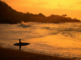 Surfer Standing at Waimea Bay at Sunset, Waimea, U.S.A. Photographie par Ann Cecil