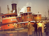 Men at pier looking at 3 Tugboats, One Named 