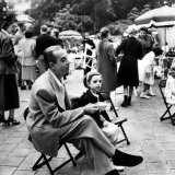 Vincente Minnelli with coffee sitting in chair with Daughter Liza at Outdoor Children's Party Being Impressão fotográfica premium por J. R. Eyerman