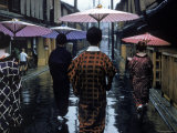 Geishas Carry Umbrellas of Oiled Japanese Paper Wearing Geta Walking in Rain, Gion Geisha Quarter Reproduction photographique sur papier de qualité par Eliot Elisofon
