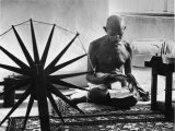 Indian Leader Mohandas Gandhi Reading as He Sits Cross Legged on Floor Premium fotografisk trykk av Margaret Bourke-White