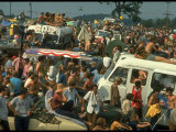 Crowd of people, some Sitting on Top of Cars and Busses, During the Woodstock Music/Art Fair Photographic Print by John Dominis