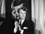 Robert F. Kennedy Campaigning in Front of Poster Portrait of His Brother President John F. Kennedy Premium Photographic Print by Bill Eppridge
