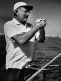 Author Ernest Hemingway at Wheel of Fishing Boat During Fishing Tournament Reproduction photographique sur papier de qualité par Alfred Eisenstaedt
