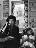 Jackie Kennedy, Wife of Senator John Kennedy, Talking on the Telephone as her daughter mimics her Photographic Print by Alfred Eisenstaedt