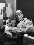 Architect Le Corbusier Sitting in Chair and Holding Book in Hands Reproduction photographique sur papier de qualité par Nina Leen