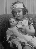 Evelyn Mott playing Nurse with doll as parents adjust children to abnormal conditions in wartime Photographic Print by Alfred Eisenstaedt