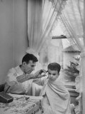 B.F. Goodrich Engineer Frank Herzegh Developed the Tubeless Tire, Cutting his son Frankie's hair Photographic Print by Alfred Eisenstaedt