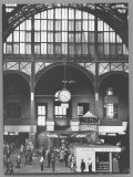Bustling Interior Showing Digital and Standard Clocks and Ironwork Arches of Penn Station Photographie par Walker Evans