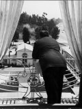 Suit Clad Movie Director Alfred Hitchcock as He Leans on Balcony Railing of Apartment Premium Photographic Print by Peter Stackpole