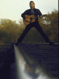 Country/Western Singer Johnny Cash with Guitar Straddling Railroad Tracks Premium-Fotodruck von Michael Rougier