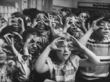 Classroom Full of Students Circling Fingers Around Eyes in Form of Glasses During Music Class Photographie par Francis Miller