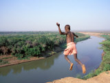 Karo Boy Leaps Off a Cliff Over the Omo River, Ethiopia Fotografisk tryk af Janis Miglavs