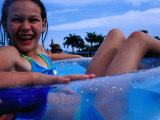 Young Girl Floating in Swimming Pool in Rubber Ring, Gold Coast, Australia Photographic Print by Richard I'Anson