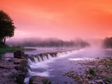 Sunrise in the morning mist over the waterfall on the Venta River near Kuldiga, Latvia Photographie par Janis Miglavs