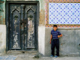 Boy Standing Near Door of Historic House, Baghdad, Iraq Photographie par Jane Sweeney