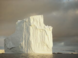 Twilight View of a Large Iceberg Under a Cloudy Sky Photographic Print