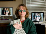 A Female Wears Circuit Glasses in Front of Two Computer Monitors Photographic Print by Joel Sartore
