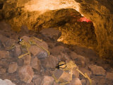Two Skeletons Crawl up a Rocky Hill in a Cave Photographic Print by Taylor S. Kennedy