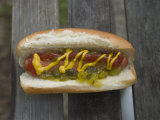 A Hot Dog is Covered in Condiments Like Mustard, Ketchup and Relish Photographic Print by Stephen Alvarez