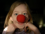 A Young Female Sports a Bright Red Clown Nose Photographic Print by Joel Sartore