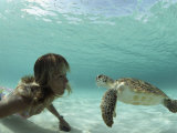 A Young Woman Swimming Face-To-Face with a Green Sea Turtle Photographic Print by Bill Curtsinger