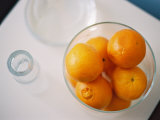 Oranges in Bowl Next to Drinking Glass Photographic Print by Elisa Cicinelli