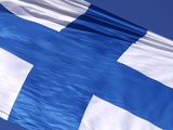 Close-up of the Flag of Finland on White Fabric with a Blue Cross Against Blue Sky Photographic Print