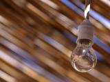 Close-up of a Single Bare Light Bulb Against a Blurred Background Photographic Print