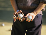 A Man Holding Two Balls Waiting His Turn to Play Bocci Photographic Print by Michael Melford