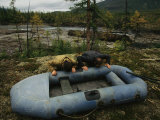 Two Men Use Lung Power to Top Off Their Inflatable Raft Photographic Print by Randy Olson