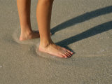 Feet in the Wet Sand of a Beach Wait for the Next Surge of Surf Photographic Print by Paul Damien