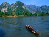 Longboat Crossing Nam Song from Limestone Formations with Honeycomb Caves, Vang Vieng, Laos Photographic Print by Kraig Lieb